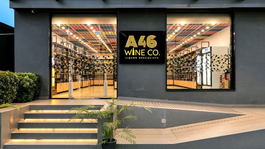 The exterior of a wine shop named A46 Wine Co with large windows displaying rows of wine bottles | The Citi Residenci Hotel Banskopa
