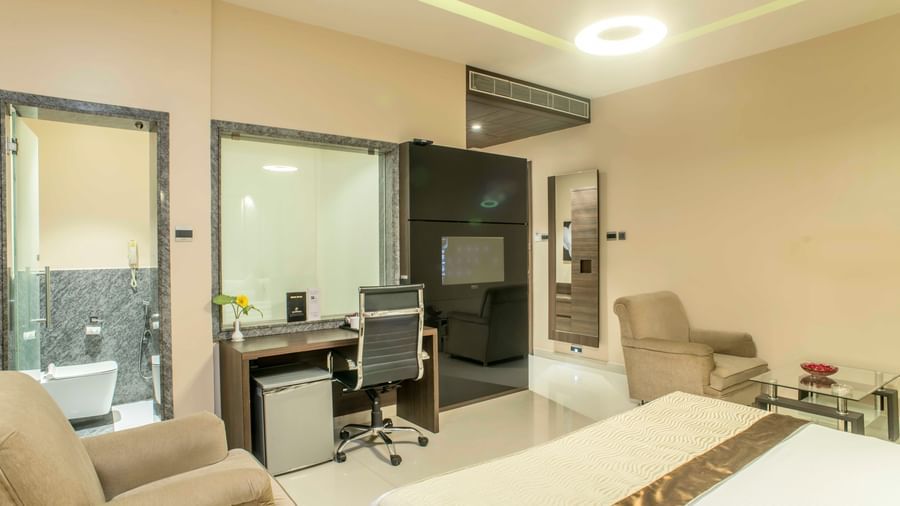 Modern hotel suite with a king size bed, a separate living area, and a glass-enclosed bathroom | The Citi Residenci Hotel Durgapur