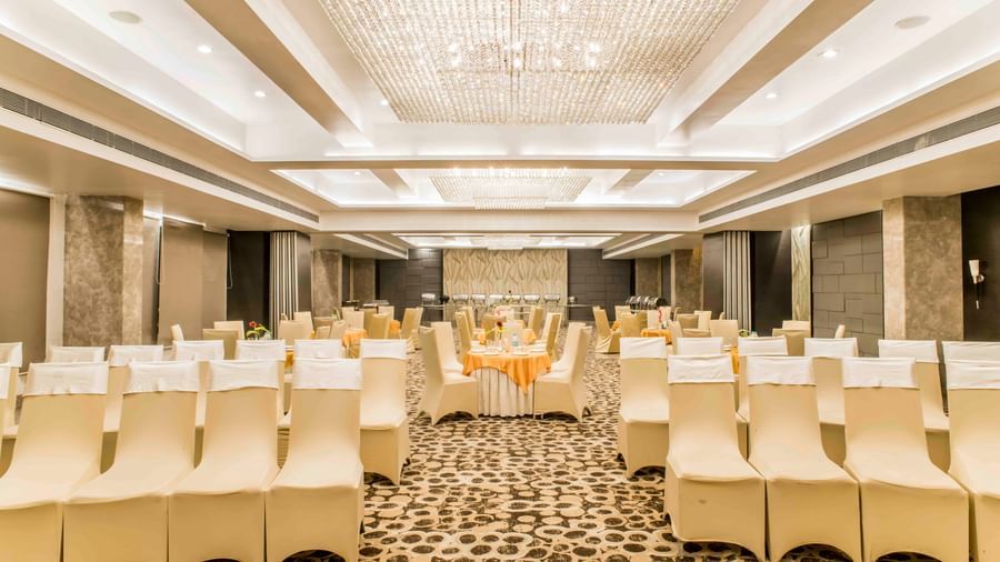 A wide view of a banquet hall with neatly arranged tables and chairs at The Citi Residenci Hotel, Durgapur.