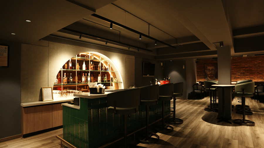 Citrine Hotel | A bar counter with bottles placed on shelves.