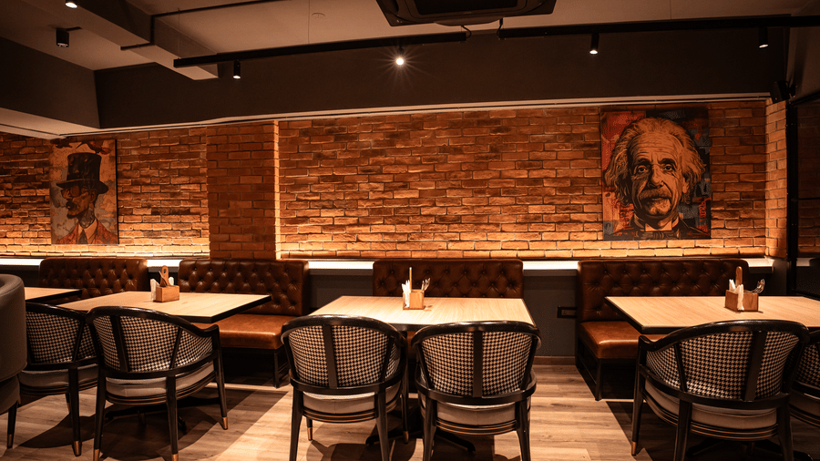 Warm and stylish dining area at Trino Bar with ambient lighting and brick wall decor.