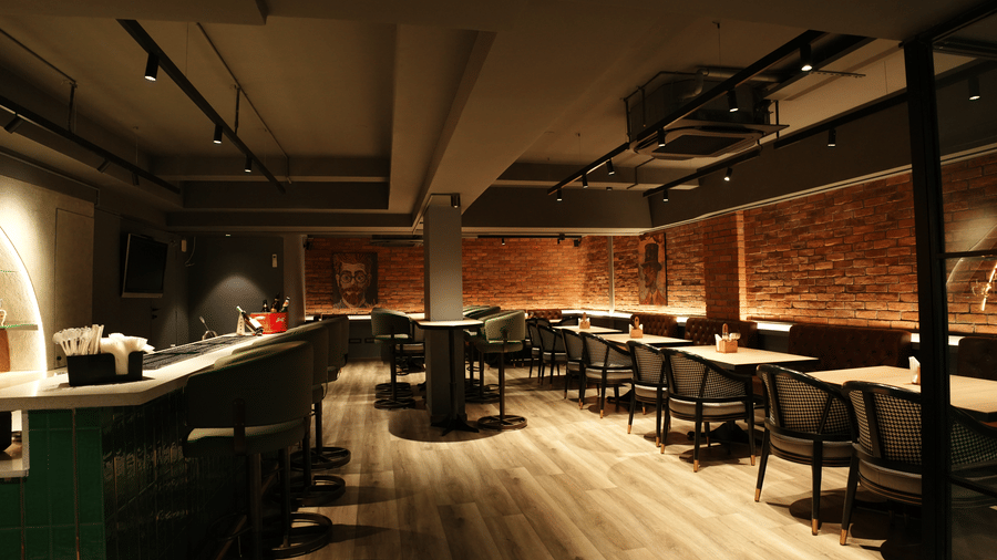 Citrine Hotel | A bar seating area with chairs, tables and counter at the left corner.