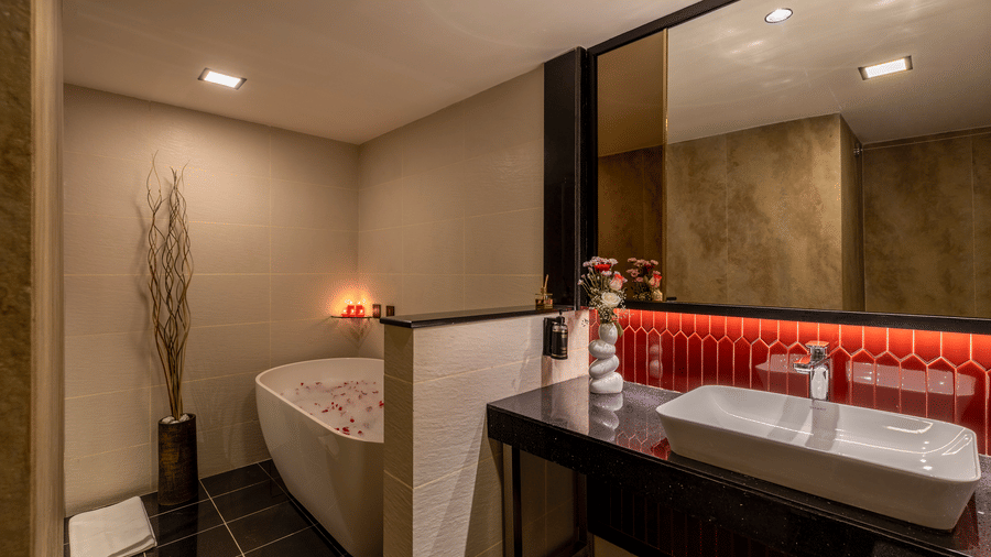 Luxury hotel suite bathroom with contemporary fixtures, elegant tile work, and a deep bathtub at The Citrine, Bangalore.