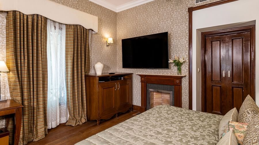 image of the club room with a king size bed and a wall mounted TV at Club Rooms at The Claridges Nabha Residence