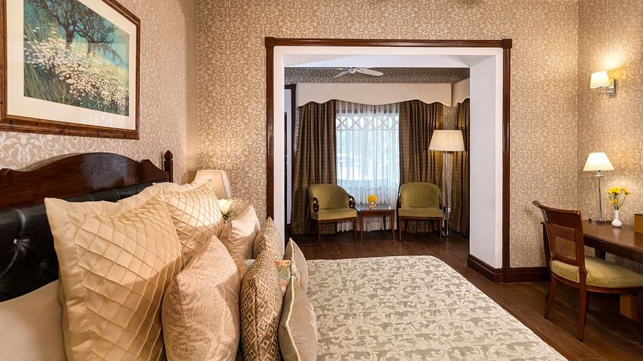 image of the king size bed and the seating area of the Club Room at The Claridges Nabha Residence