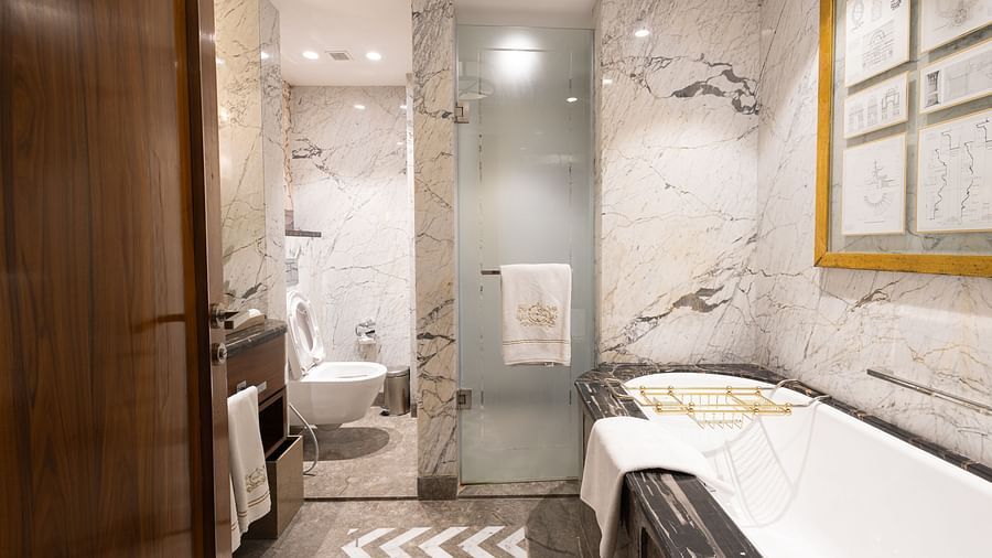 Luxury King Bed Room washroom at The Claridges New Delhi, featuring a bathtub and a glass-enclosed bath area