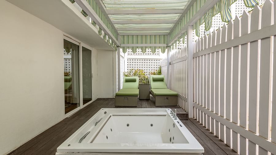 Luxury Suite with Whirlpool at The Claridges New Delhi, featuring a private small pool under a shaded area and lounge chairs arranged in the corner