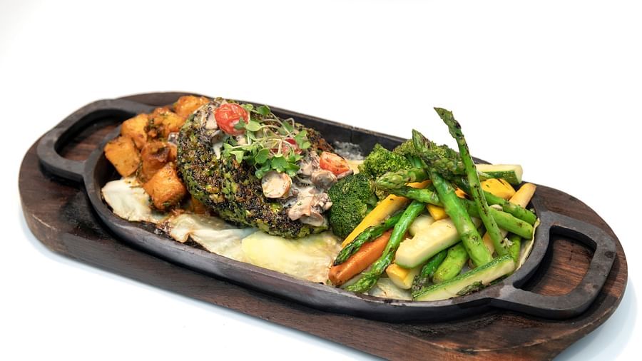 Image featuring a sizzling grilled steak with roasted vegetables and herb-infused sauce