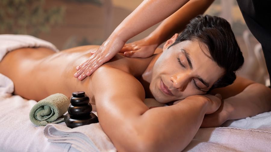 image of a man with his eyes closed enjoying a shoulder massage at the sumaya - The Claridges New Delhi