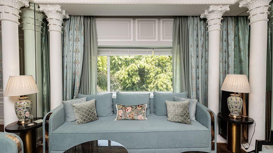 An image of a blue couch with lamps placed on either side of it at the Diplomatic suite room - The Claridges New Delhi