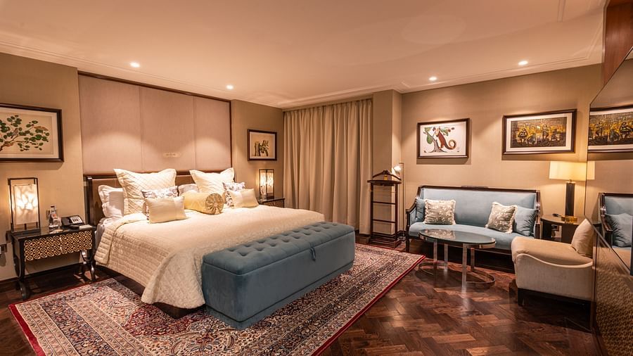 a full view image of the cabana room in its full grandeur featuring the king size bed and the seating area along with elegant interiors throughout - The Claridges New Delhi 