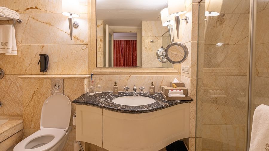 image of the bathroom in the regent suite with a sink and an in built vanity area and a cubical shower - The Claridges New Delhi