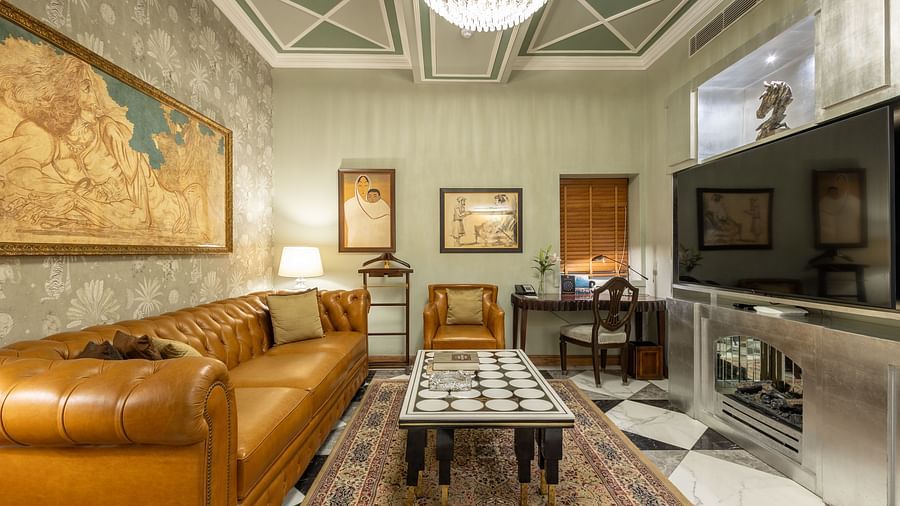 full view of the living room with huge photo frames and a comfortable elegant couch at our heritage luxury suite - The Claridges New Delhi