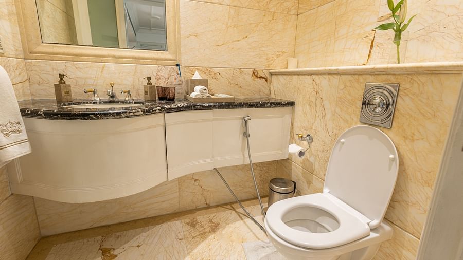 image of the bathroom with a vanity area in under the sink and commode - The Claridges New Delhi 