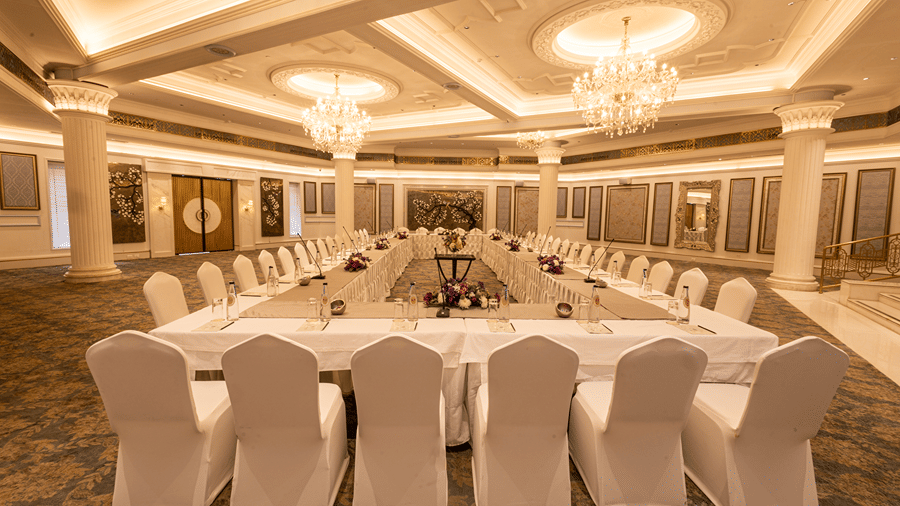Image featuring the Viceroy Hall event venue at The Claridges New Delhi, showcasing seating arrangements and an elegant chandelier hanging overhead