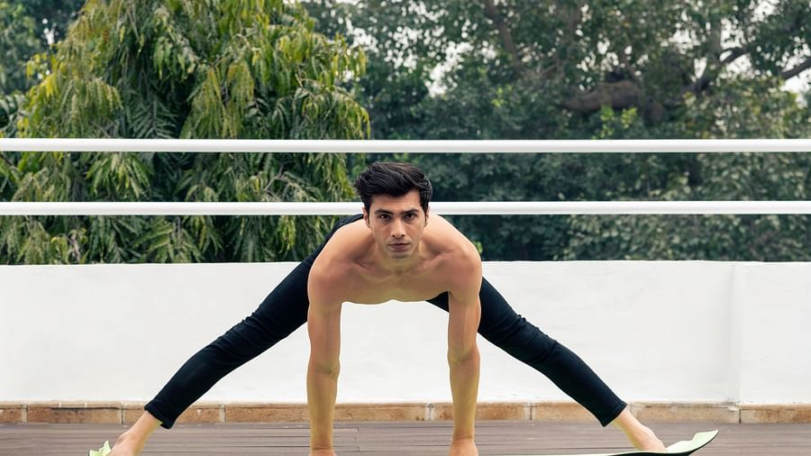 A person performing an asana on a mat - The Claridges New Delhi