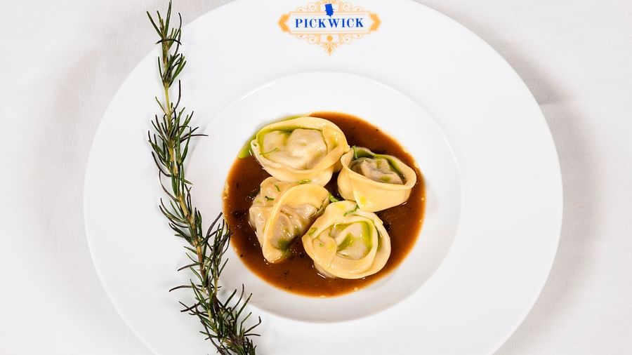 image of soupy dumplings with rosemary leaves served at the puckwick restaurant - The Claridges New Delhi
