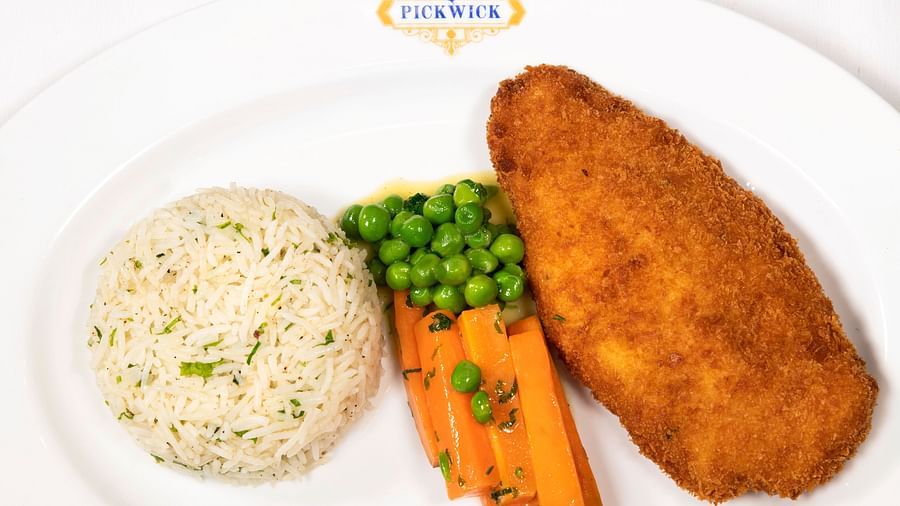 image of a fried chicken breast with steamed rice with corrot peas served by the pickwick multi cuisine restaurant - The Claridges New Delhi