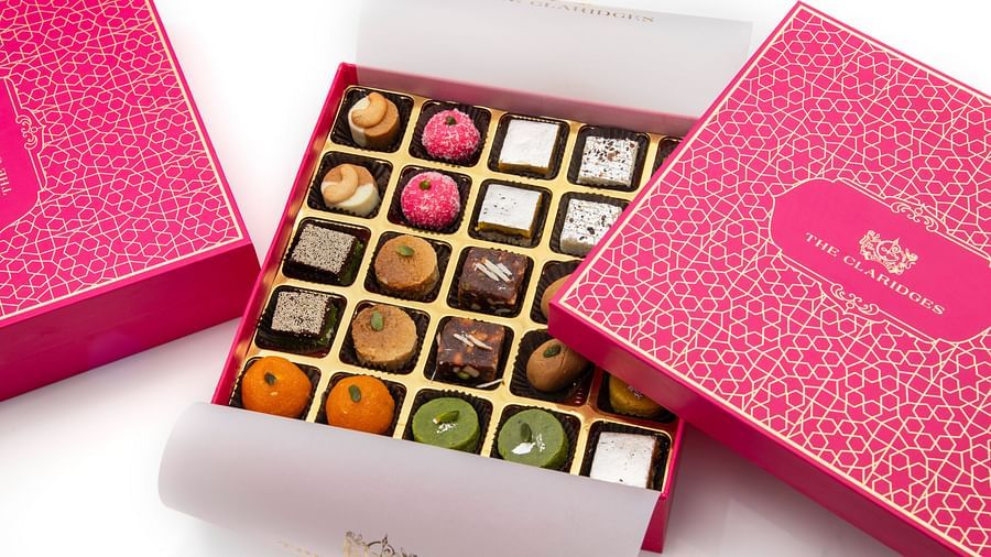 a pink box with assorted indian sweets - The Claridges New Delhi