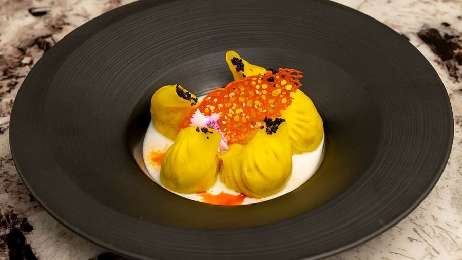 image of yellow coloured dimsums served with a white cream sauce at the jade - The Claridges New Delhi