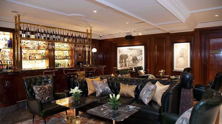 image of the elephant bar with elegant black leather couches at The Claridges New Delhi