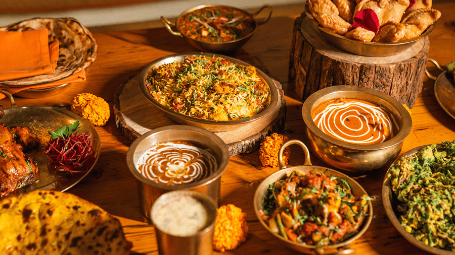 A festive Holi feast by Dhaba, featuring a delicious spread of traditional food, beautifully presented on a rustic wooden table