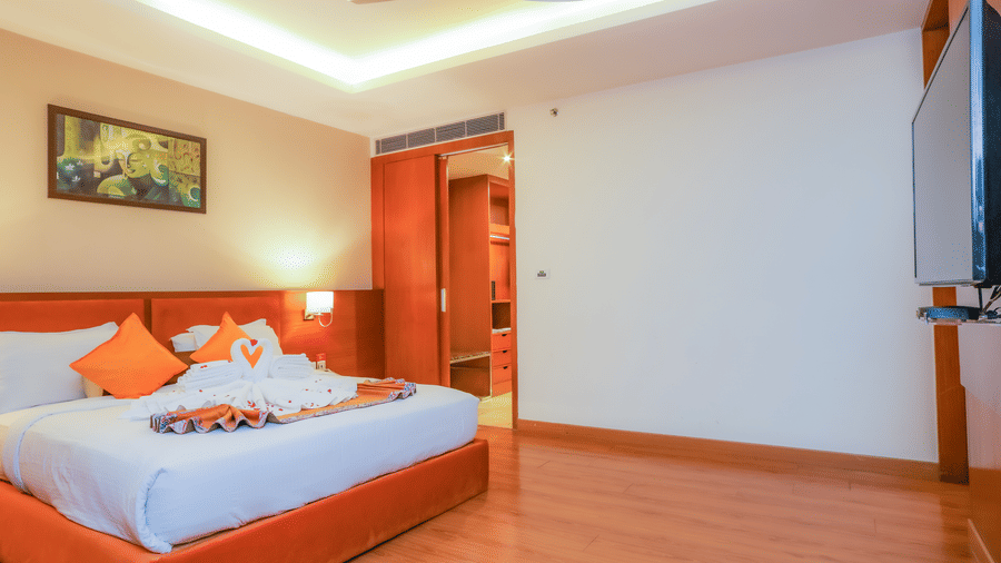 A spacious and well-appointed hotel suite bedroom with a large bed and ample space at The Conway, Meerut.