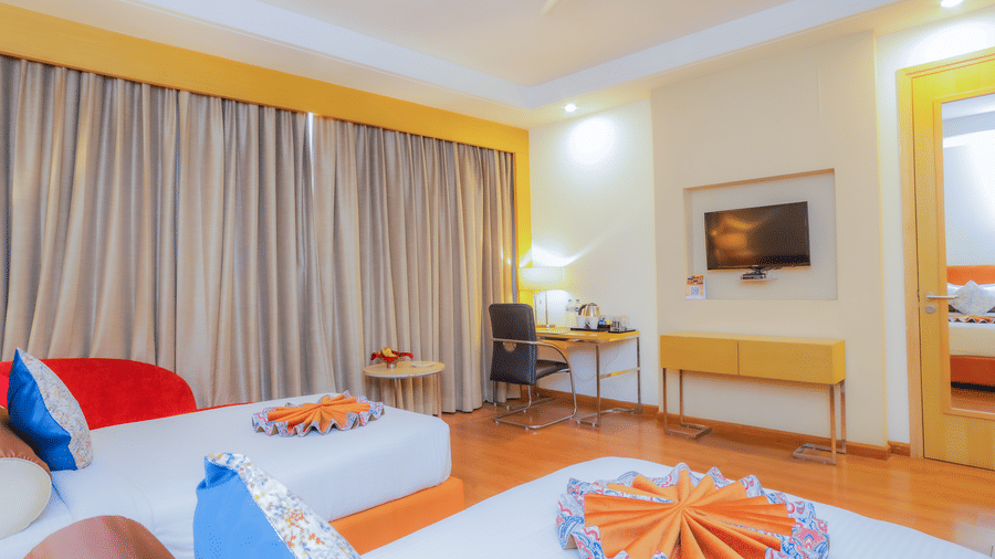 A well-appointed hotel room featuring a large bed and a cosy seating area at The Conway, Meerut.