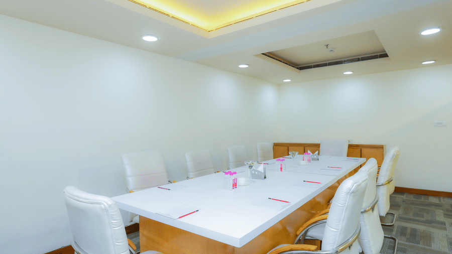 Another view of a contemporary meeting room with a long conference table and white chairs at The Conway, Meerut.