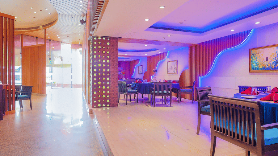 A side view of the restaurant's interior, featuring modern decor and ambient purple lighting at The Conway, Meerut.