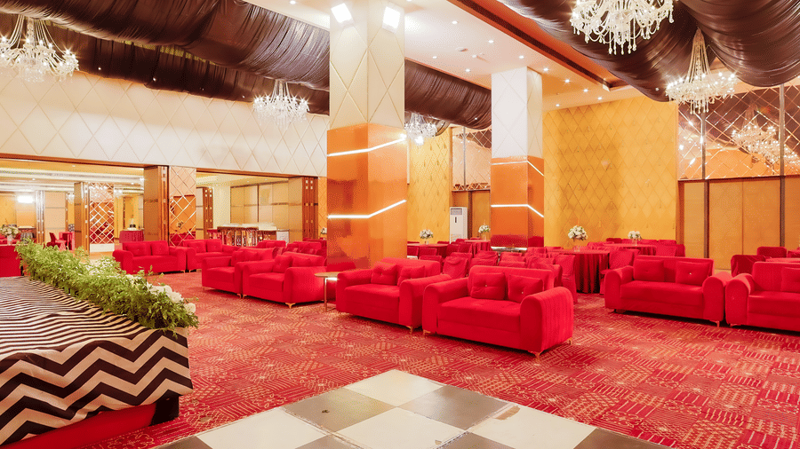 A stylish hotel lounge area with comfortable red sofas and elegant decor at The Conway, Meerut.