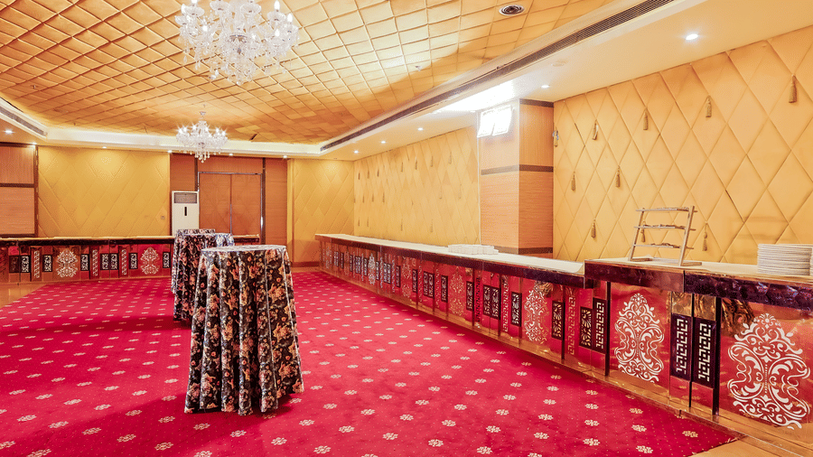A well-appointed bar counter within a banquet hall, featuring a patterned carpet at The Conway, Meerut.