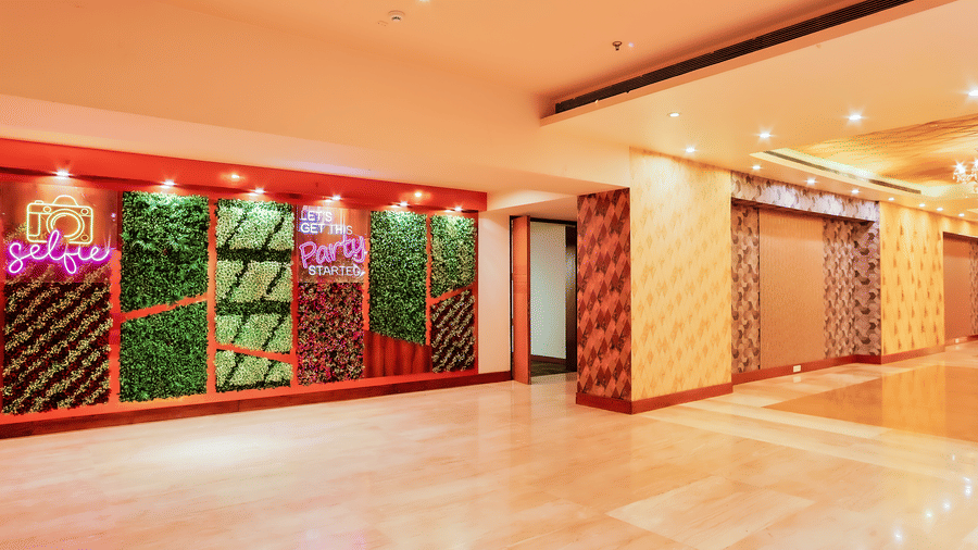 A spacious lobby area featuring a decorative green wall and polished marble flooring at The Conway, Meerut.