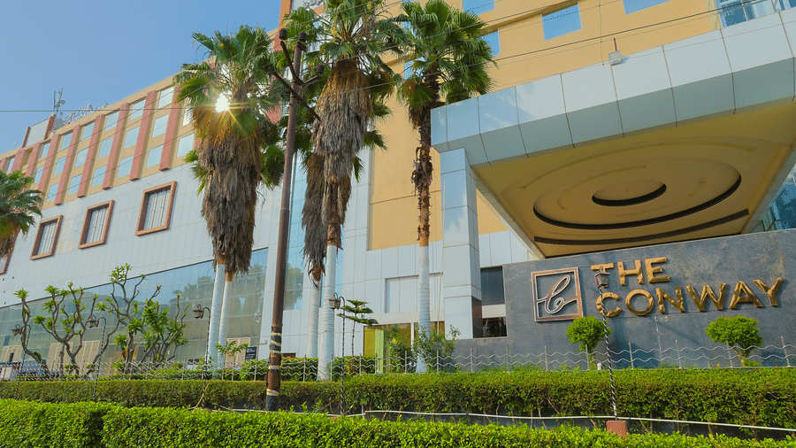 The modern exterior of The Conway hotel, featuring palm trees and a welcoming entrance at The Conway, Meerut.