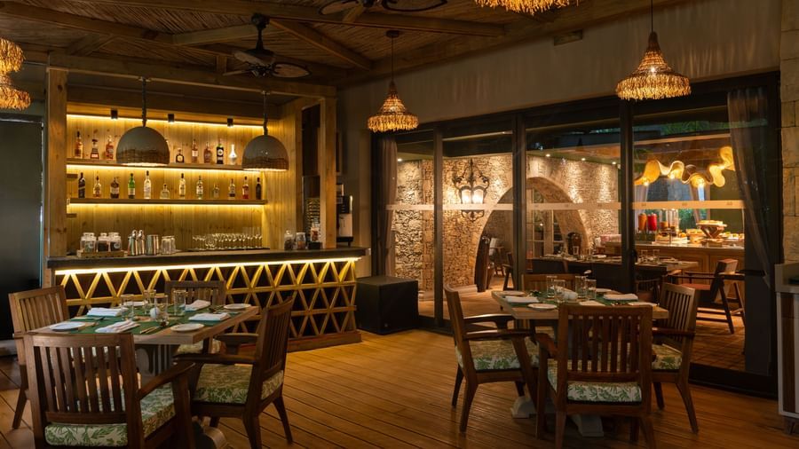 The indoor dining area of Mila Restaurant at The Evren, Vagator, with elegant lighting.