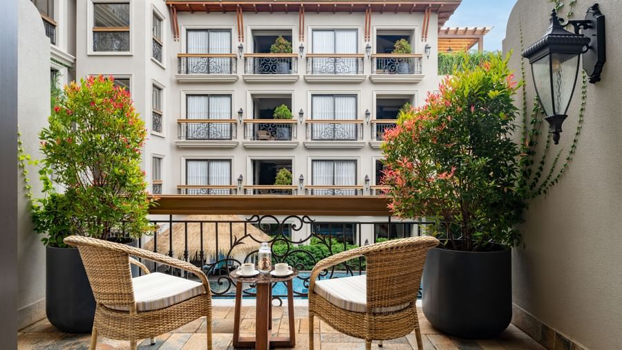 Back shot of the outdoor sit-out area in a balcony of the Premium Room overlooking the swimming pool.