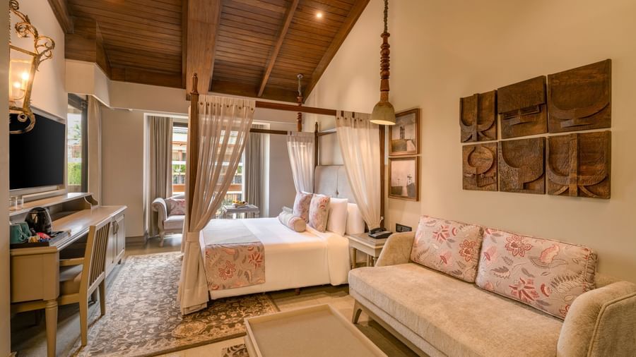 Full-view shot of the Executive Room featuring common seating area along with a double bed in the room at The Evren, Vagator.