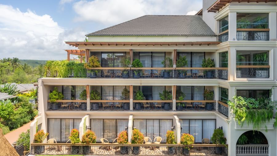 A bright facade of The Evren, Vagator, featuring the corridors decorated with plants.