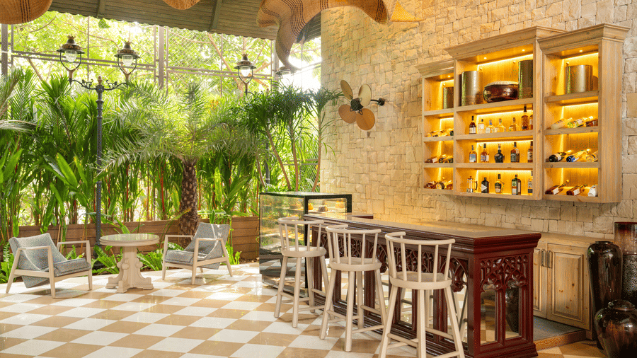 The Suenos de Cafe at The Evren showcasing tables, chairs, greenery, and open wall shelving.