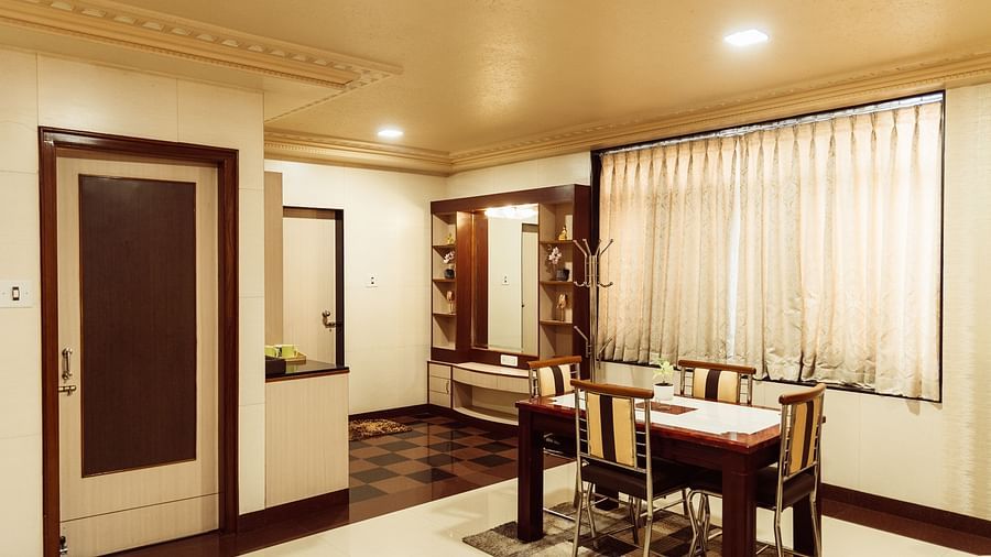 image of a living area of the Grand suite at The Grand Krishna Rooms, Bengaluru featuring a four-seater dining area