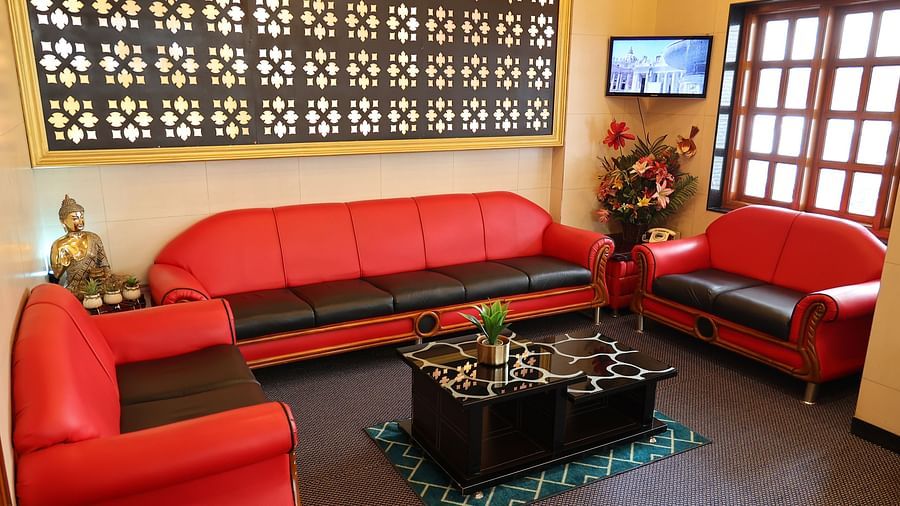 image of the seating area at The Grand Krishna Rooms with red coloured couch and a centre table
