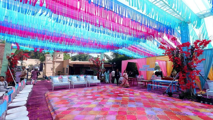 A wedding venue with colourful  fabric draping overhead, a patterned aisle, and decorated tables awaiting guests - The Grand Legacy Resort & Spa
