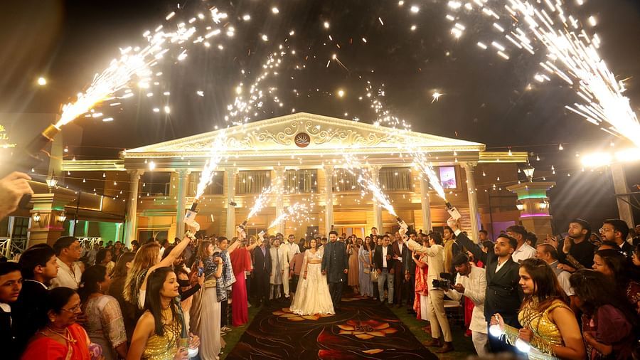 Bride and groom walking down the aisle and people are bursting fireworks towards them as a mean to celebrate their union - The Grand Legacy Resort & Spa