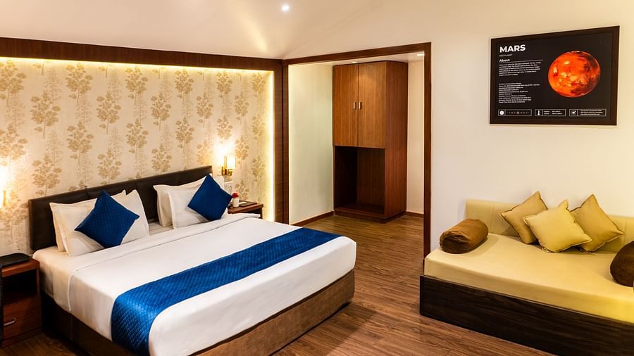 Lawn View Tent Room at The Grand Legacy Resort and Spa featuring room with double bed, blue accents, warm lighting, wood flooring, a lounge area, and Mars-themed wall art.