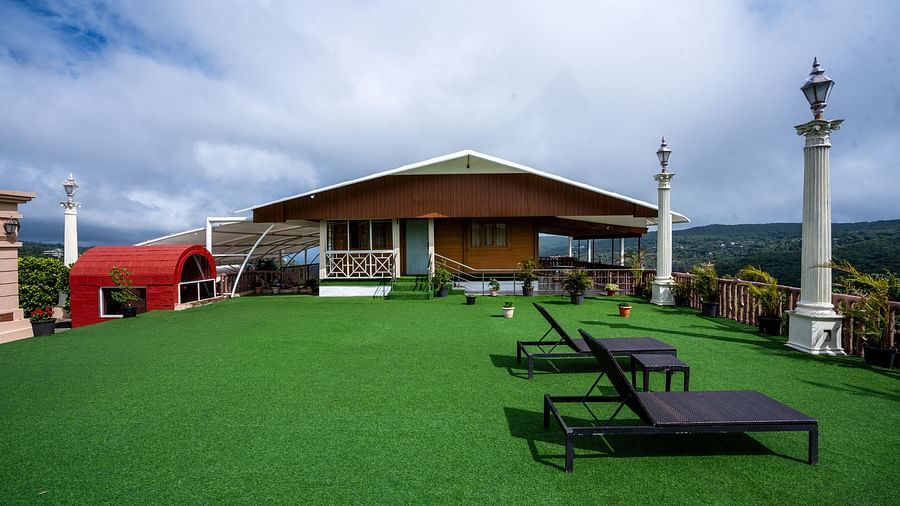A wide-angle view of the lawn area at The Grand Legacy Resort and Spa, featuring beach chairs and the stay area.