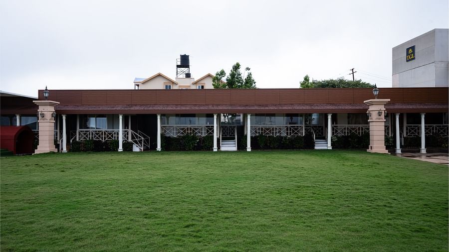 A wide-angle view of The Grand Legacy Resort and Spa, showcasing the large lawn area and a water tank situated above the building.