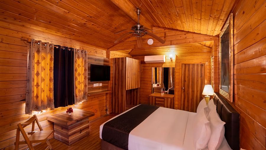 A modern, stylish room with a wooden ceiling, featuring a large bed and elegant lighting for a warm ambience.