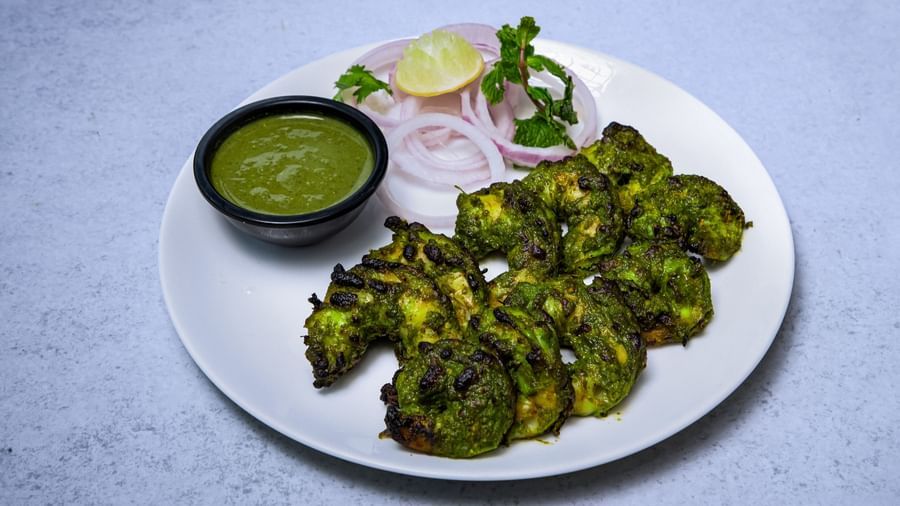 A plate of appetiser with a small bowl of green sauce and onion rings placed on side at The Hamuse Hotel, Kodaikanal.