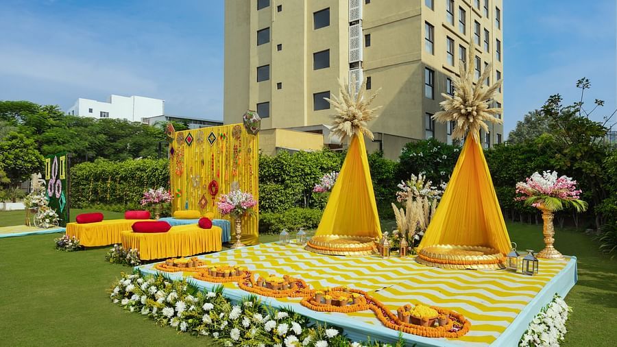 a stage set with two specially decorated seats and more seating arrangements beside the stage - The Hideaway Banquets & Lawns, Greater Noida