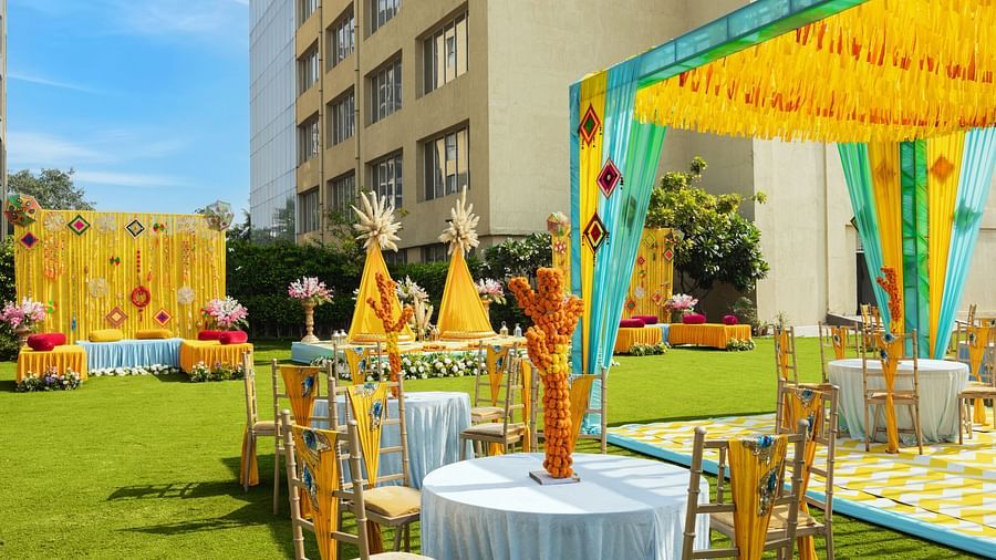 a view of an event space with tables and chairs in clusters and a canopy with tables underneath - The Hideaway Banquets & Lawns, Greater Noida